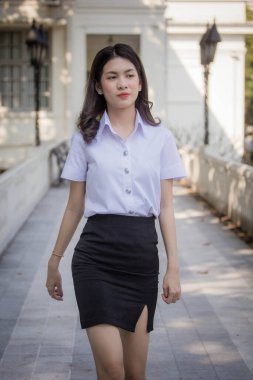 Taylandlı yetişkin öğrenci üniforması güzel kız rahatla ve gülümse.