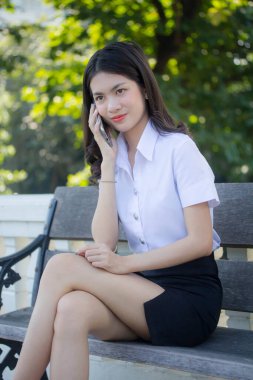 Taylandlı yetişkin öğrenci üniforması güzel kız rahatla ve gülümse.