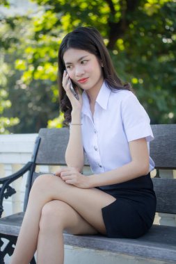 Taylandlı yetişkin öğrenci üniforması güzel kız rahatla ve gülümse.