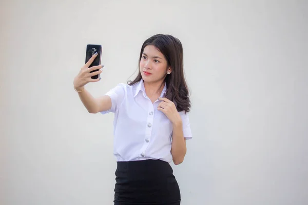 タイの成人女子大生制服美少女使用彼女のスマートフォンSelfie — ストック写真