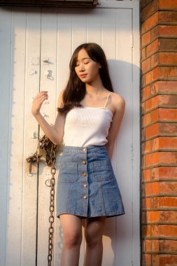 Tayland portresi yetişkin güzel kız beyaz gömlek mavi kot rahatla ve gülümse