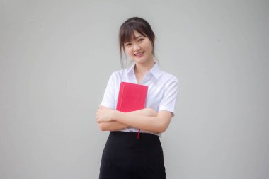 Taylandlı yetişkin üniversite üniforması güzel kız ve kırmızı kitap.