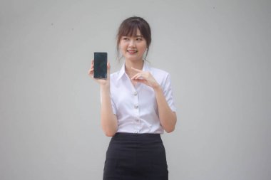 Taylandlı yetişkin üniversite üniforması güzel kız akıllı telefonunu göster.