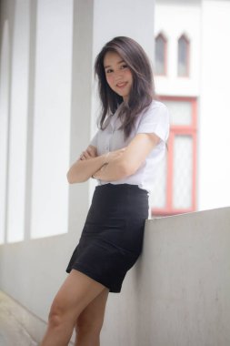 Taylandlı yetişkin öğrenci üniforması güzel kız rahatla ve gülümse.