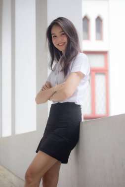 Taylandlı yetişkin öğrenci üniforması güzel kız rahatla ve gülümse.