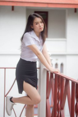 Taylandlı yetişkin öğrenci üniforması güzel kız rahatla ve gülümse.