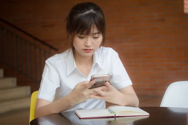 자신의 스마트폰을 사용하는 타이성 대학생 유니폼을 아름다운 소녀의 — 스톡 사진