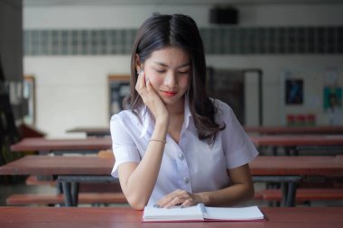 Taylandlı yetişkin öğrenci üniforması güzel kız rahatla ve gülümse.
