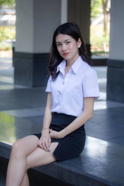 Taylandlı yetişkin öğrenci üniforması güzel kız rahatla ve gülümse.