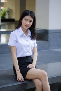 Taylandlı yetişkin öğrenci üniforması güzel kız rahatla ve gülümse.