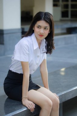 Taylandlı yetişkin öğrenci üniforması güzel kız rahatla ve gülümse.