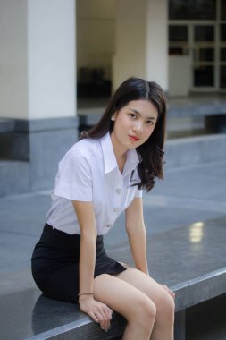 Taylandlı yetişkin öğrenci üniforması güzel kız rahatla ve gülümse.