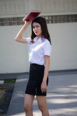 Taylandlı yetişkin öğrenci üniforması güzel kız rahatla ve gülümse.