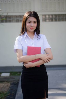 Taylandlı yetişkin öğrenci üniforması güzel kız rahatla ve gülümse.