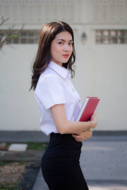 Taylandlı yetişkin öğrenci üniforması güzel kız rahatla ve gülümse.