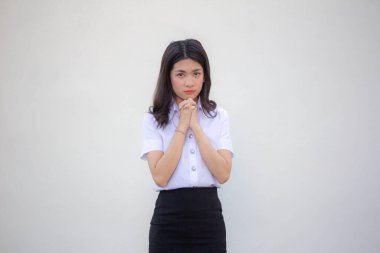 Yetişkin öğrenci üniforması. Güzel kız dua ediyor.