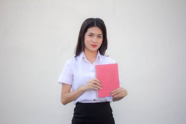 Taylandlı yetişkin öğrenci üniforması güzel kız kırmızı kitap gösteriyor.