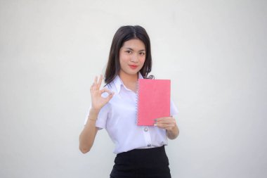 Taylandlı yetişkin öğrenci üniforması güzel kız kırmızı kitap gösteriyor.