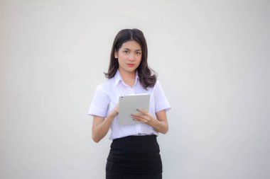 Yetişkin öğrenci üniforması. Tabletini kullanan güzel bir kız.