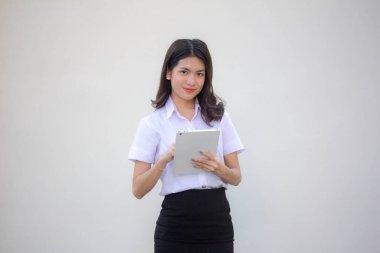 Yetişkin öğrenci üniforması. Tabletini kullanan güzel bir kız.