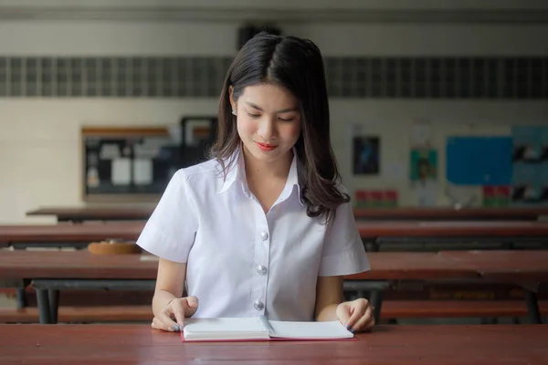 thai adult student university uniform beautiful girl read red book