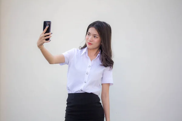 タイの成人女子大生制服美少女使用彼女のスマートフォンSelfie — ストック写真