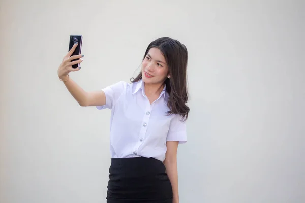 タイの成人女子大生制服美少女使用彼女のスマートフォンSelfie — ストック写真