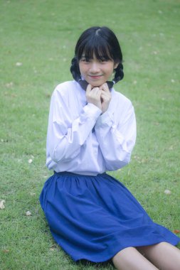 Taylandlı liseli üniformasının portresi. Genç güzel kız mutlu ve rahat.