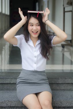 Taylandlı yetişkin öğrenci üniforması güzel kız rahatla ve gülümse.