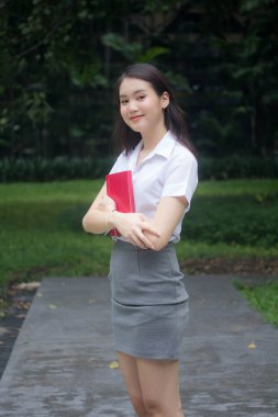 Taylandlı yetişkin öğrenci üniforması güzel kız rahatla ve gülümse.