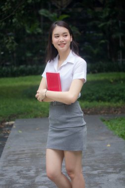 Taylandlı yetişkin öğrenci üniforması güzel kız rahatla ve gülümse.