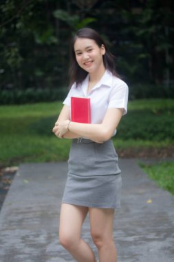 Taylandlı yetişkin öğrenci üniforması güzel kız rahatla ve gülümse.