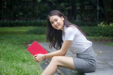 Taylandlı yetişkin öğrenci üniforması güzel kız rahatla ve gülümse.