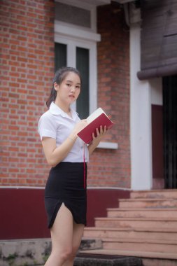 Taylandlı yetişkin öğrenci üniforması güzel kız rahatla ve gülümse.