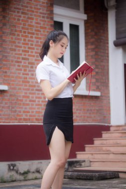 Taylandlı yetişkin öğrenci üniforması güzel kız rahatla ve gülümse.