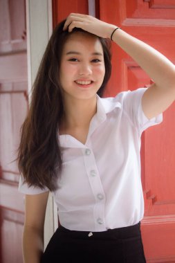 Taylandlı yetişkin öğrenci üniforması güzel kız rahatla ve gülümse.