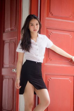 Taylandlı yetişkin öğrenci üniforması güzel kız rahatla ve gülümse.