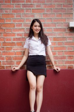 Taylandlı yetişkin öğrenci üniforması güzel kız rahatla ve gülümse.