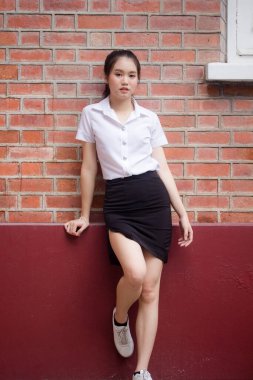 Taylandlı yetişkin öğrenci üniforması güzel kız rahatla ve gülümse.