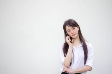 Tayland portresi yetişkin ofis kızı beyaz gömlek yürüyor ve akıllı telefon arıyor.