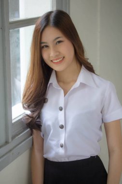 Taylandlı yetişkin öğrenci üniforması güzel kız rahatla ve gülümse.