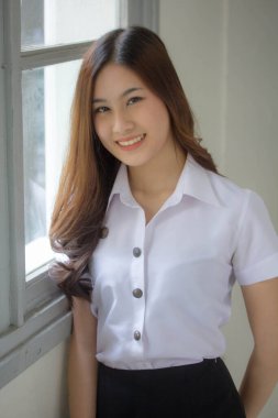 Taylandlı yetişkin öğrenci üniforması güzel kız rahatla ve gülümse.