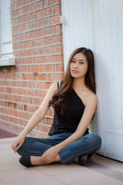 Tayland portresi yetişkin güzel kız siyah gömlek mavi kot pantolon rahatla ve gülümse