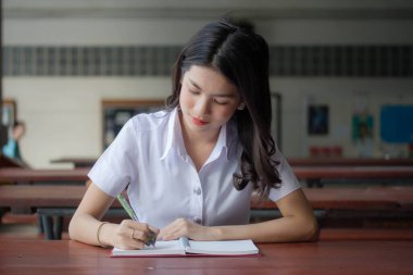Taylandlı yetişkin öğrenci üniforması güzel kız rahatla ve gülümse.
