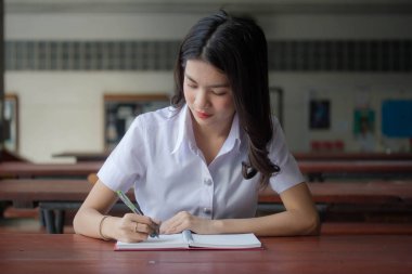 Taylandlı yetişkin öğrenci üniforması güzel kız rahatla ve gülümse.