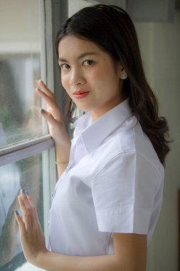 Taylandlı yetişkin öğrenci üniforması güzel kız rahatla ve gülümse.