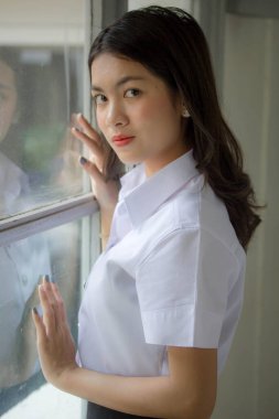 Taylandlı yetişkin öğrenci üniforması güzel kız rahatla ve gülümse.