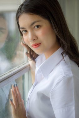 Taylandlı yetişkin öğrenci üniforması güzel kız rahatla ve gülümse.