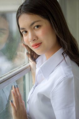 Taylandlı yetişkin öğrenci üniforması güzel kız rahatla ve gülümse.