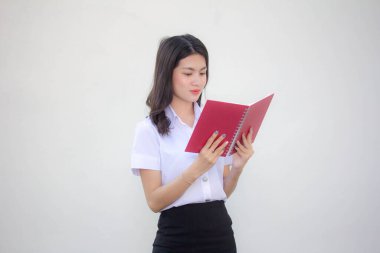 Taylandlı yetişkin üniversite üniforması güzel kız kırmızı kitabı okuyor.